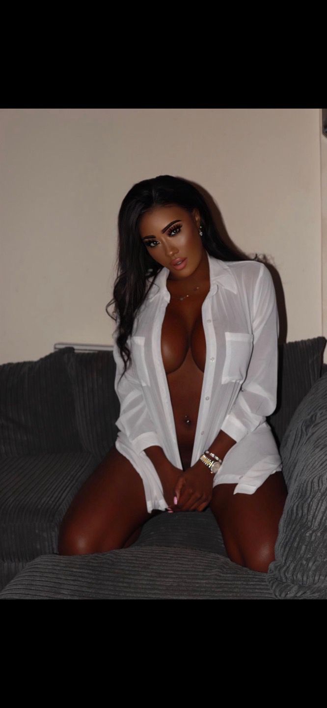 Very sexy lady wearing a boyfriend white shirt that is unbuttoned 