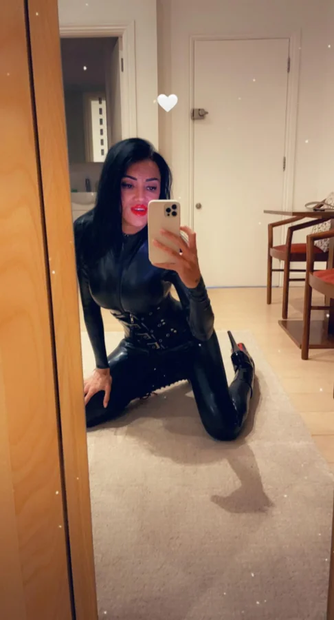 Kneeling down in her very sexy latex outfit 