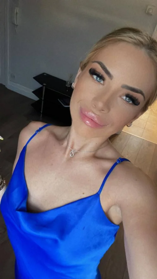 Blonde London escort Switte is wearing a blue top 