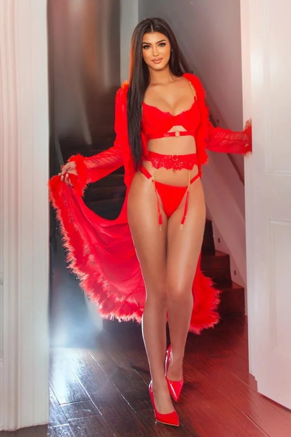 Wearing red lingerie and red high heels Simeria is standing in a doorway 