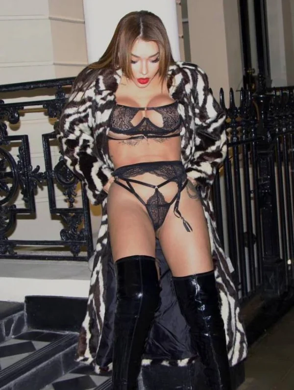 A sexy escort wearing just lingerie under a full length coat 