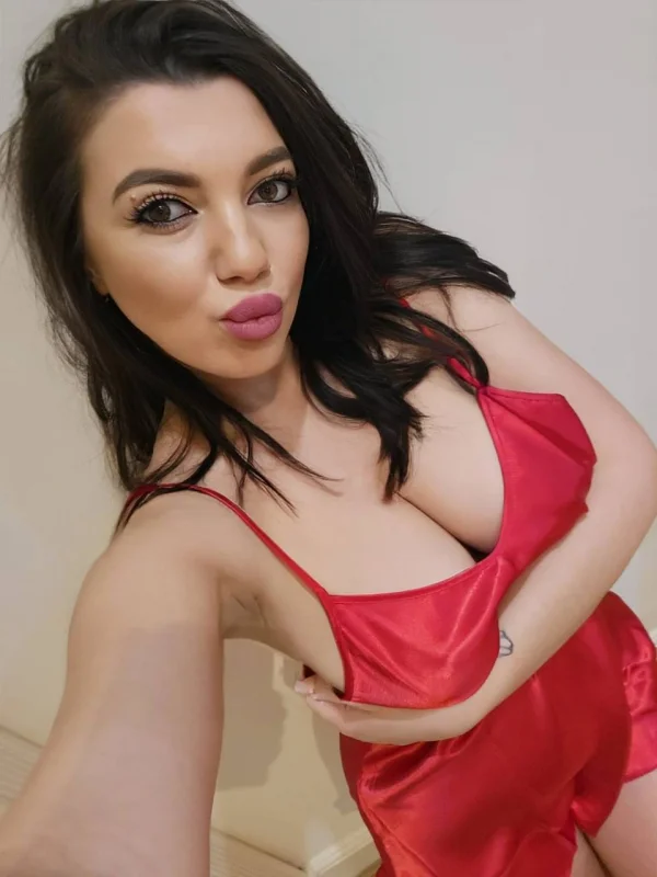 Beauty is showing off her sexy boobs in a red silk top 