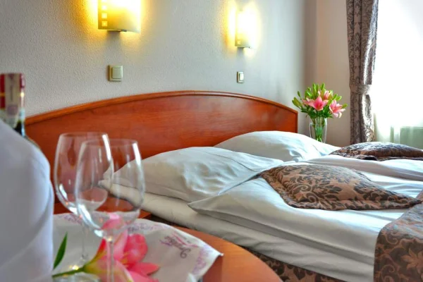 A hotel room with flowers and wine glasses