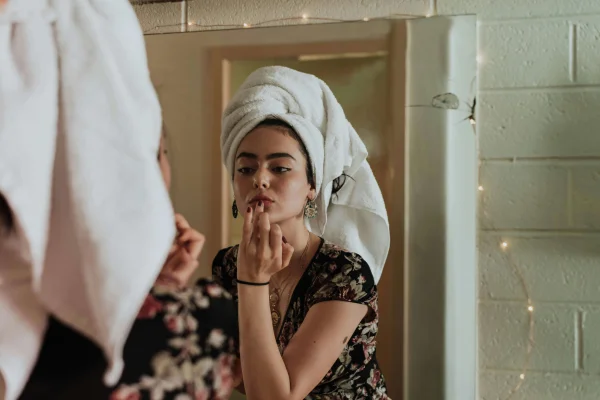 an escort doing her makeup in the mirror