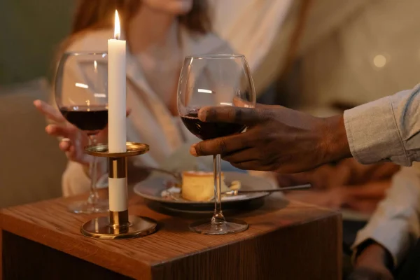 a man and a woman on a dinner date holding glasses of wine