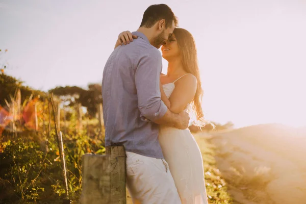 a woman and a man embracing in a field