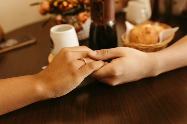 a man and a woman holding hands over a dinner table