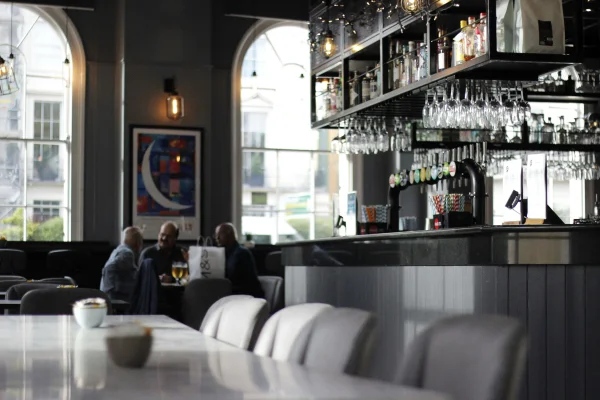 a bar in London with glasses hanging down at the bar