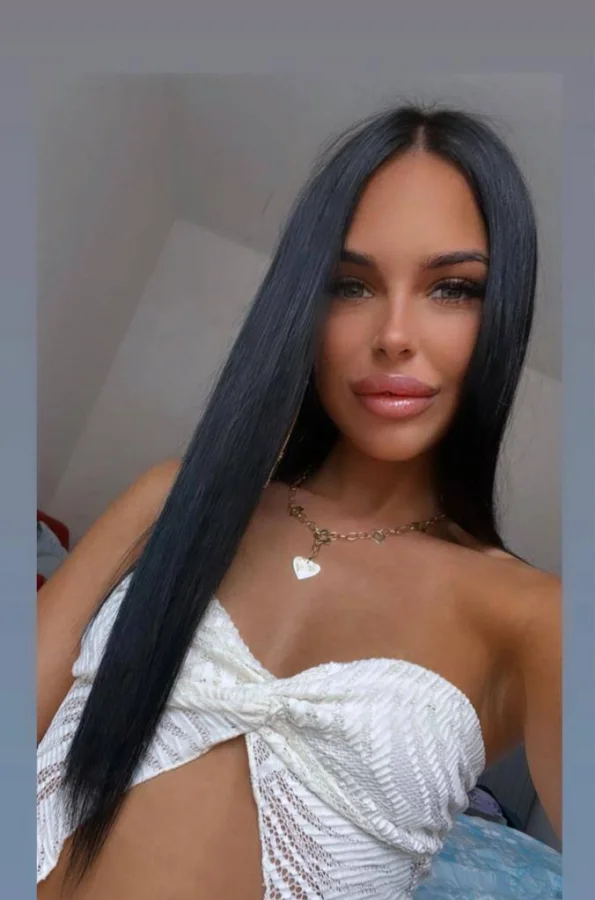 Brunette London escort Shanel is wearing a low cut white top 
