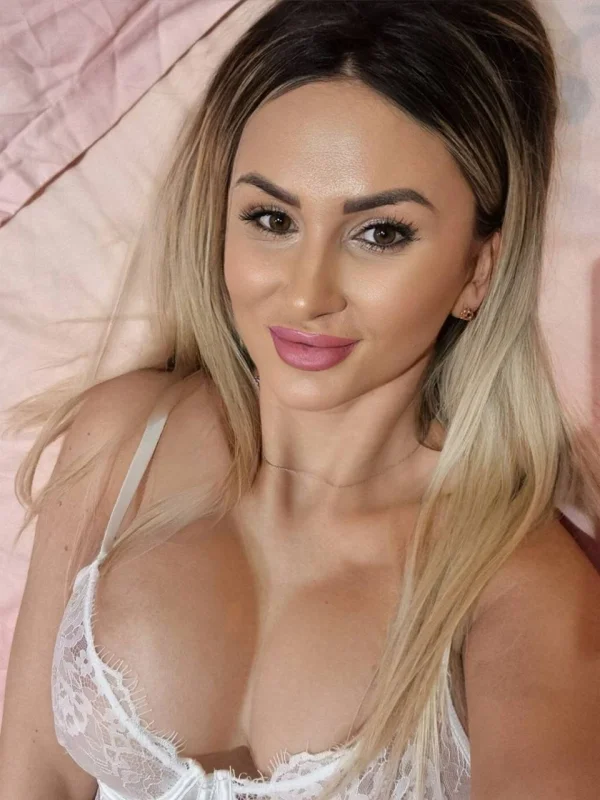 Busty blonde escort Kelly took this selfie while laying on her bed 