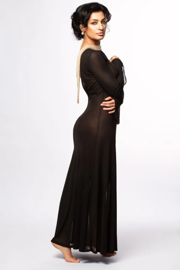 A beautiful brunette woman is dressed in a long black dress 