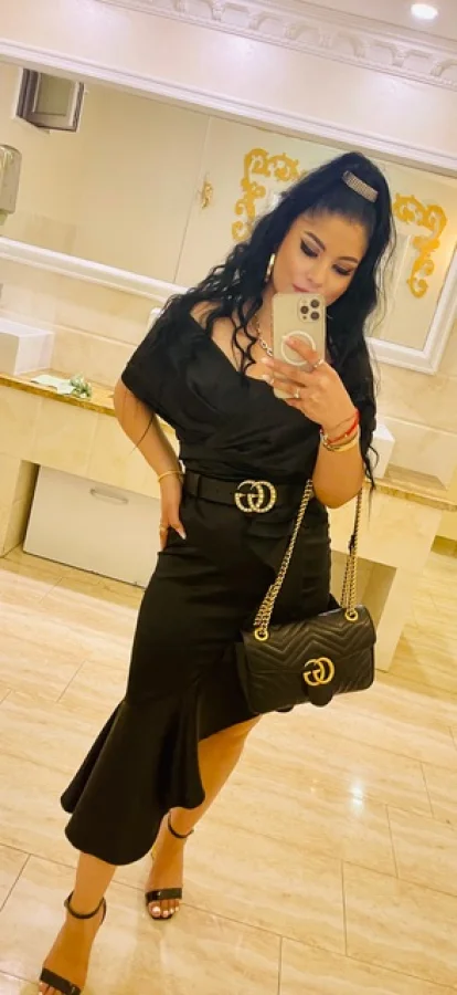 A very beautiful brunette escort took this mirror selfie of herself in a black dress 