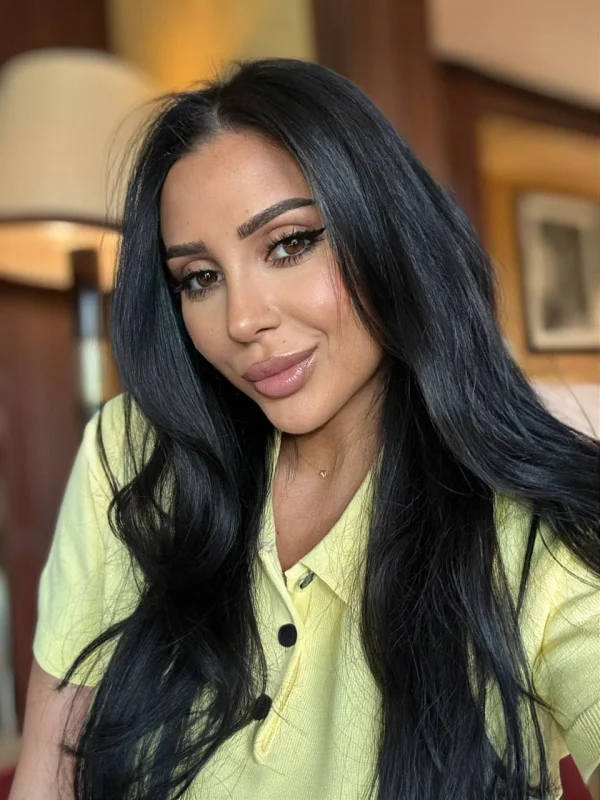A sexy brunette escort named Aylin is wearing a bright yellow shirt 