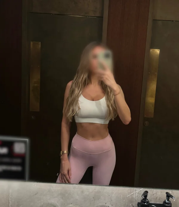 Blonde lady taking a selfie wearing sexy gym wear 
