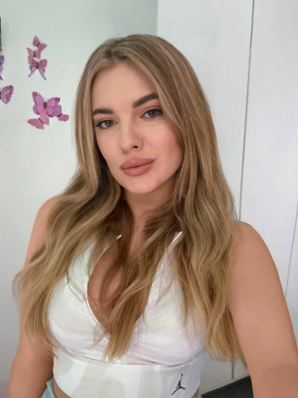 Sexy blonde escort wearing a white top 