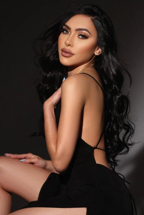 Close up photo of a beautiful brunette lady wearing a black dress 