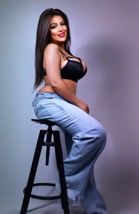Playful Hope in black bra and jeans, flirty London escort style