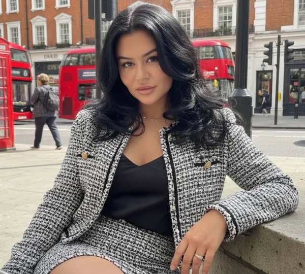 A stunning brunette escort named Reese wearing a black and white jacket 