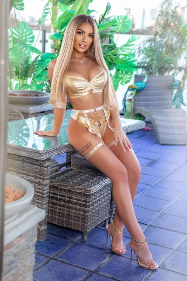 A beautiful woman wearing sexy lingerie and heels sat outside 