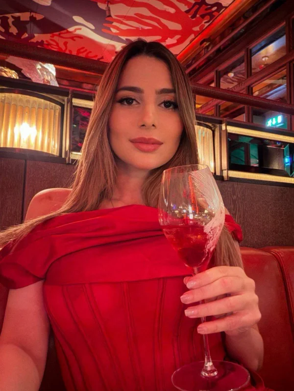 Celeste is holding up her wine glass 
