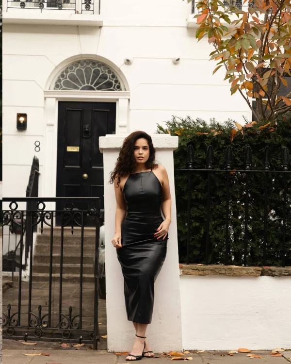 Wearing a black leather dress and high heels Liz Stormi is dressed for a night out 