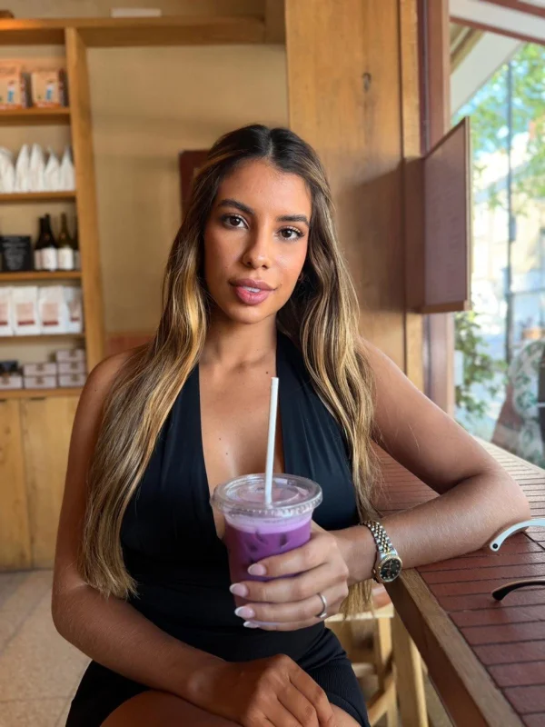 Camila is sat in a coffee shop after her work out 