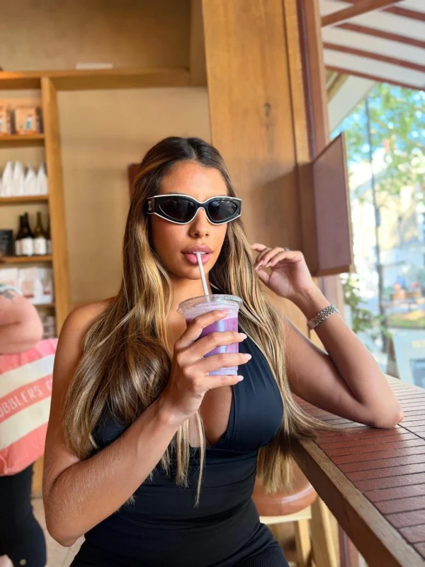 A very sexy busty woman drinking a protein shake 