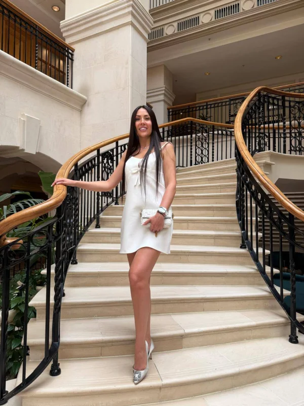 Edwina wearing a white dress that shows off her lovely long legs 