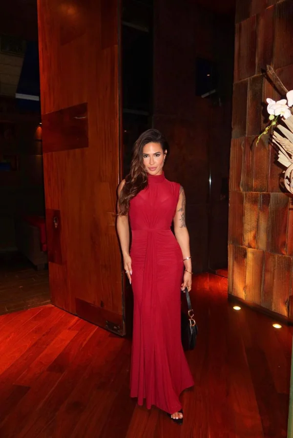 Full-length photograph of Samantha in a red gown near wooden doors