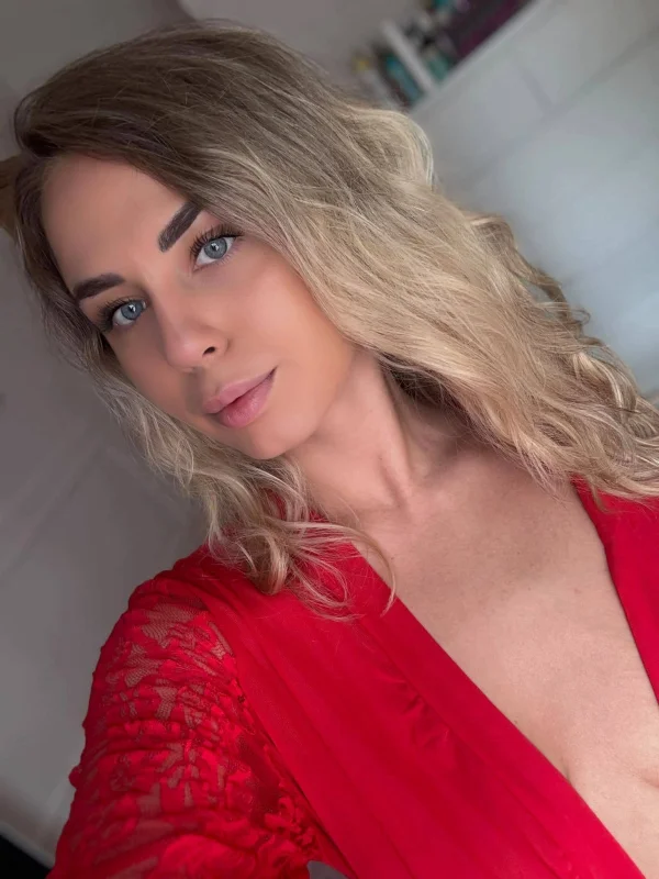 Ale wearing a red robe that has a deep V neckline 