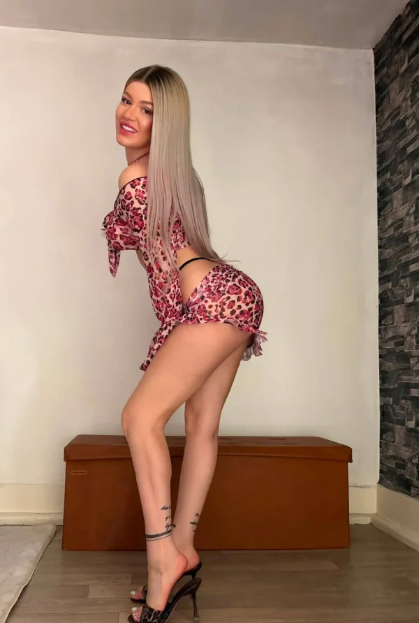 Blonde companion Mira showcasing her curves in pink patterned lingerie