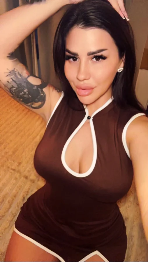 Eastern European escort Diandra in a brown fitted outfit selfie