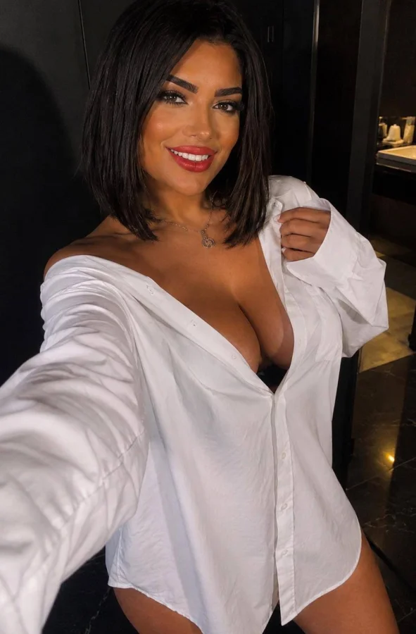 Brunette Hope wearing a loose white shirt in a modern interior