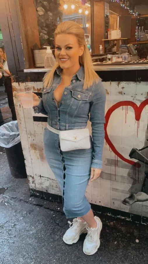 Scarlet wearing a fitted denim dress at an outdoor bar