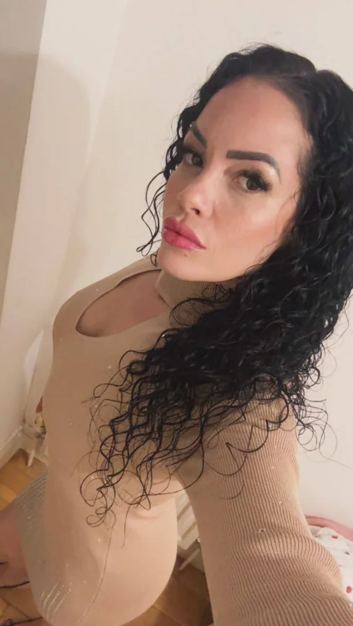Mella selfie in a beige long-sleeved dress