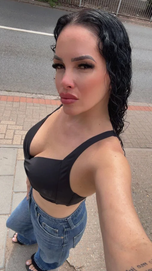 Mella outdoor selfie wearing a black crop top and jeans