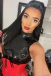 Sunny wearing a red corset and leather top 