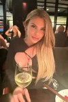 A busty blonde escort is out enjoying a glass of wine 